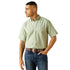 Man wearing a light green short-sleeve shirt and blue jeans on a white background